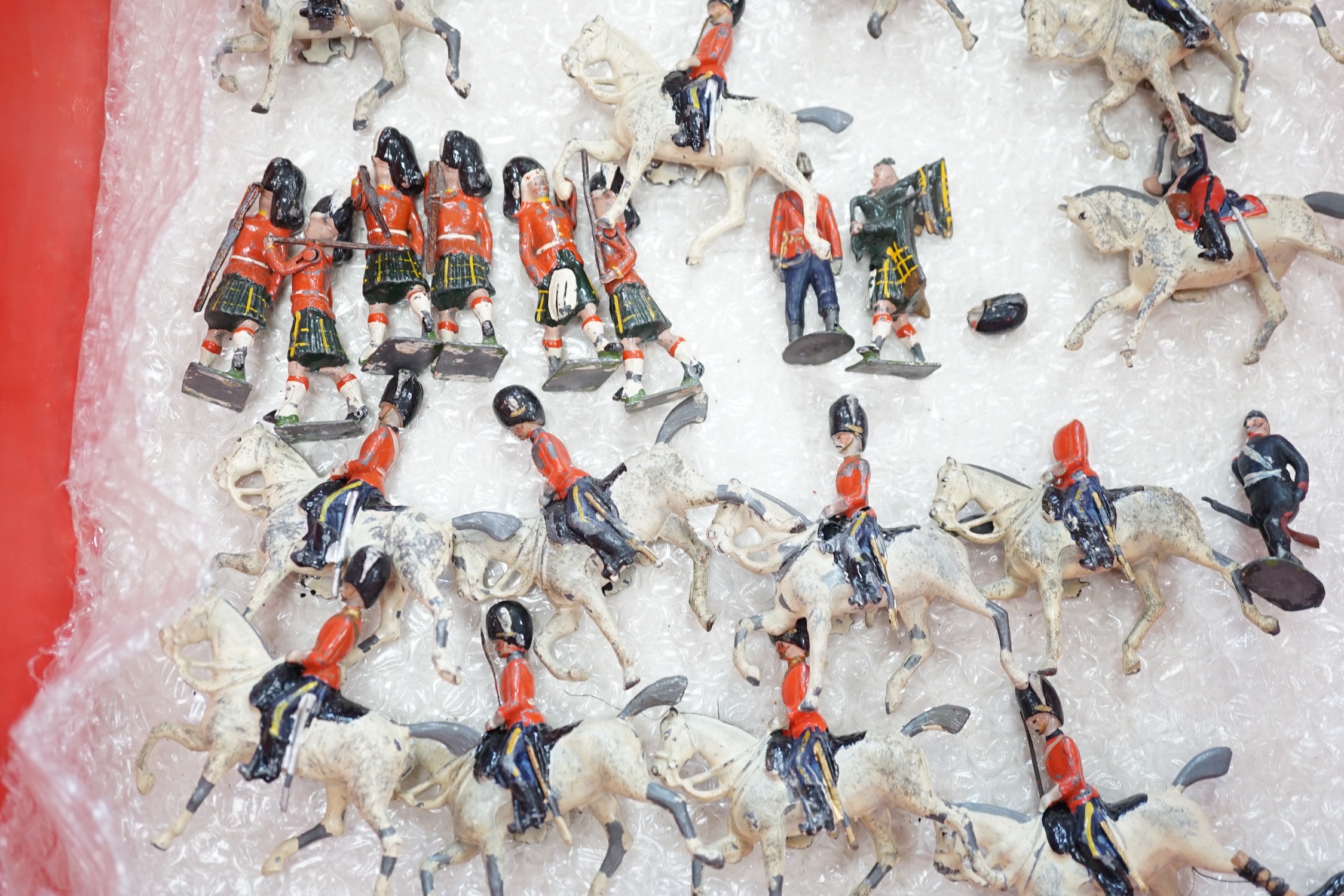 Forty-four early twentieth century Britains, etc. cavalry and infantry soldiers including; Scots Guards, mounted Grenadier Guards, bandsmen, etc. together with a field gun and tinplate lumber